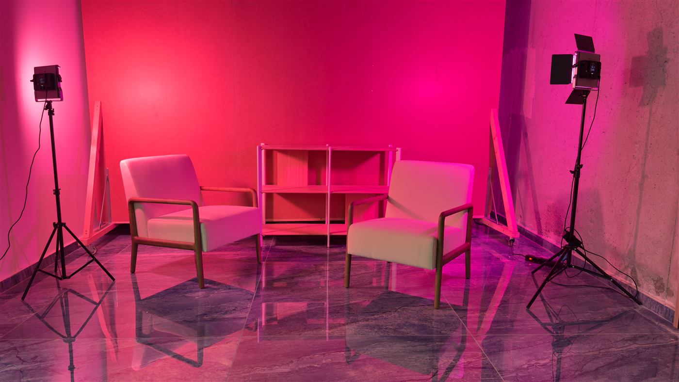 Set con fondo rosa, butacas y estantería