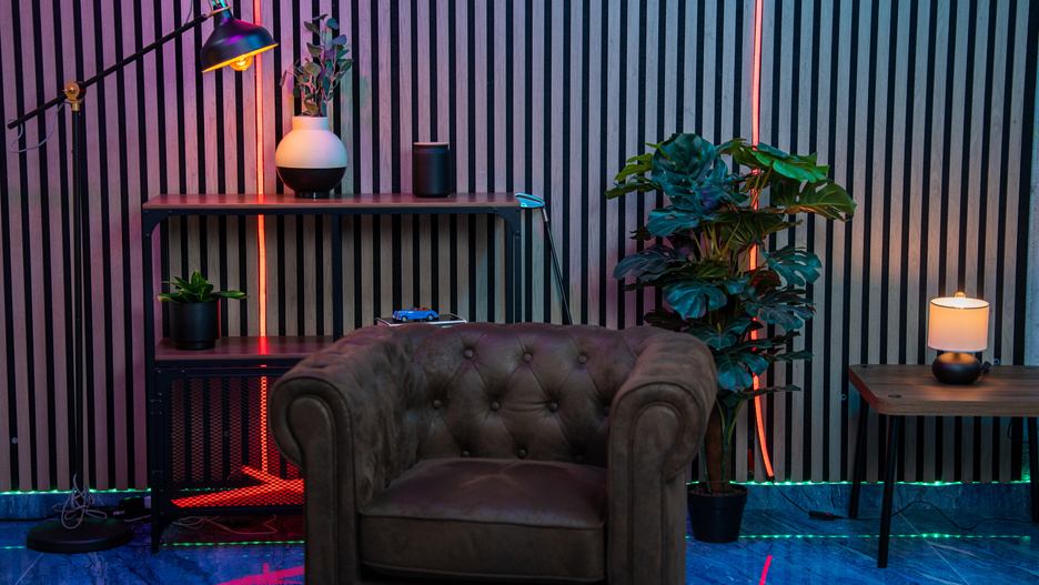 Set con listones de madera, sillón Chesterfield y luz RGB
